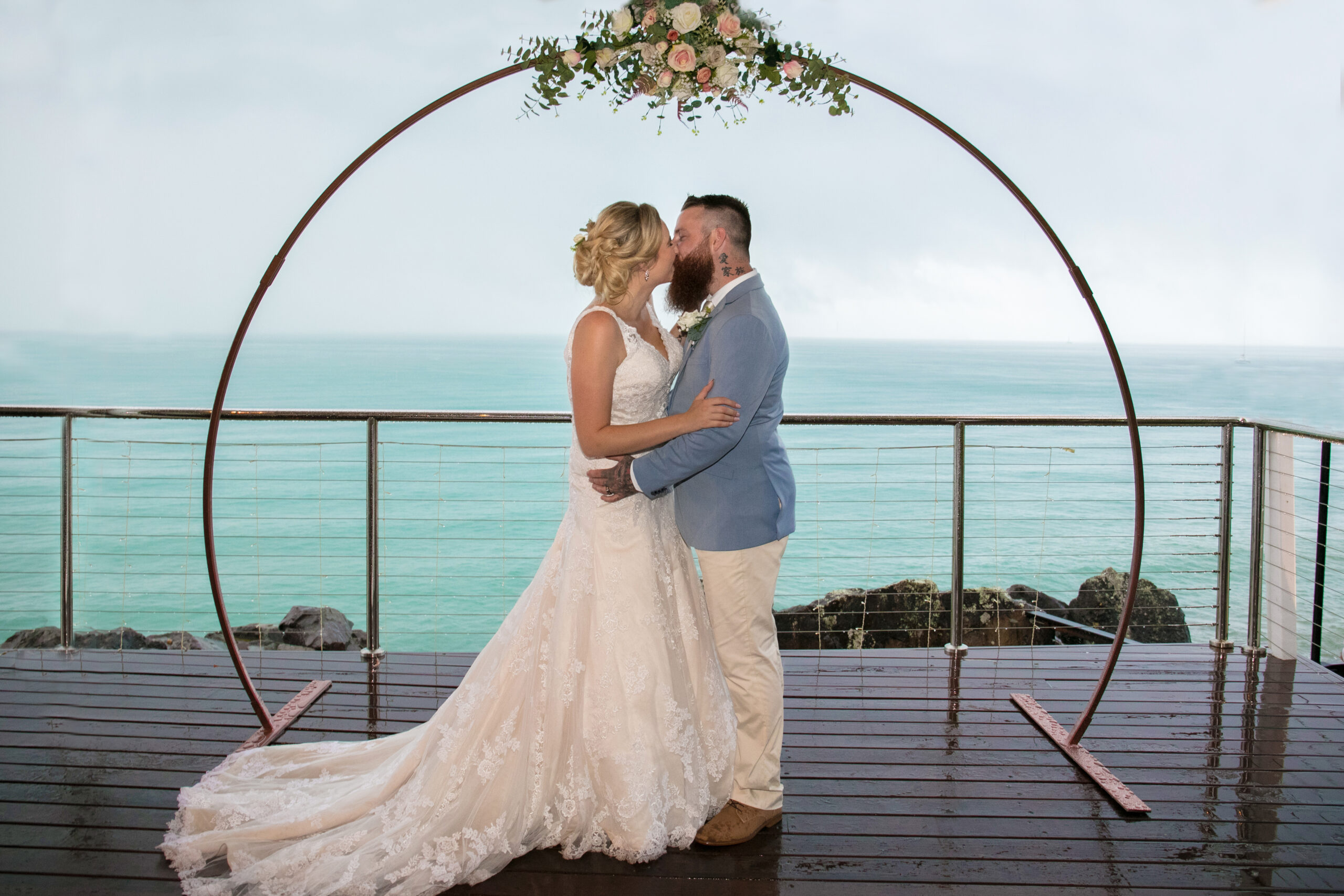 3 dishes and 2 glasses of wine on a table with an ocean view