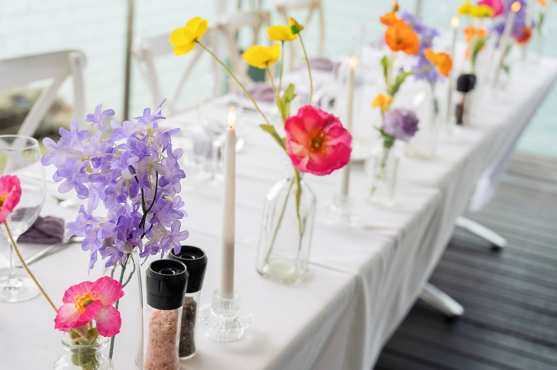 3 dishes and 2 glasses of wine on a table with an ocean view